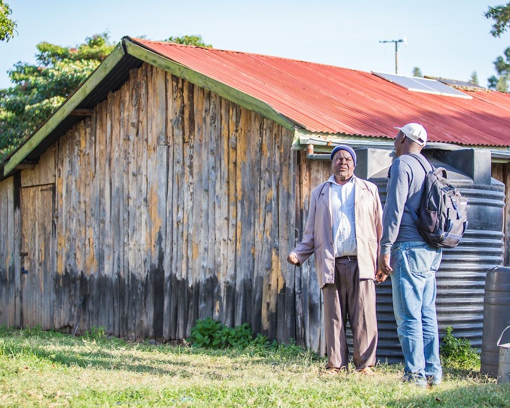 Scene of an African house two men talking outside